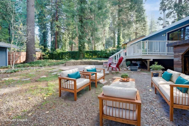 a backyard of a house with fire pit and outdoor seating