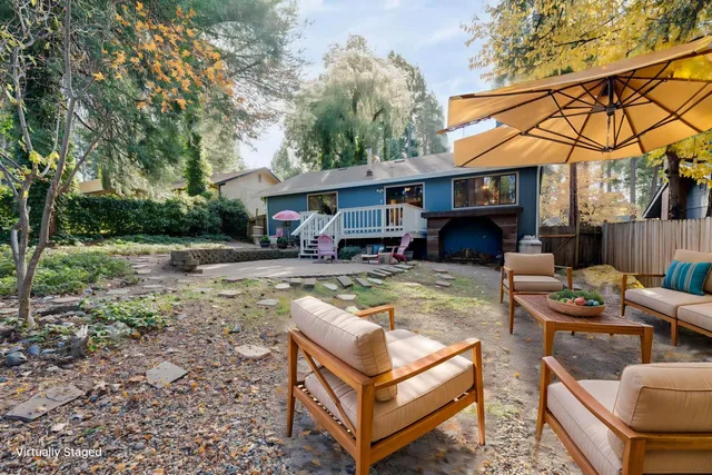a view of a house with a yard and furniture