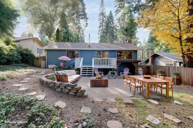 a view of a house with backyard and sitting area