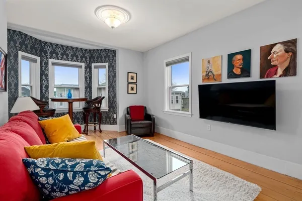 a living room with furniture a flat screen tv and a window