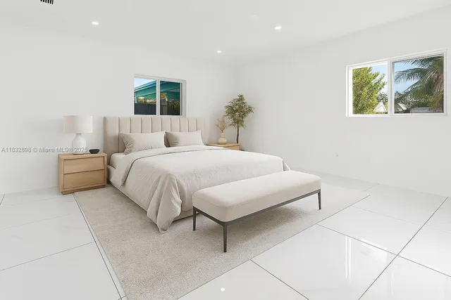 a bedroom with a large bed and a potted plant