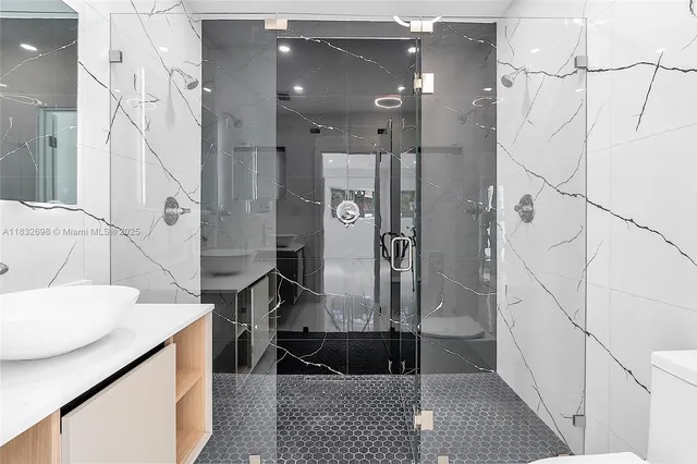 a bathroom with a sink a toilet and shower