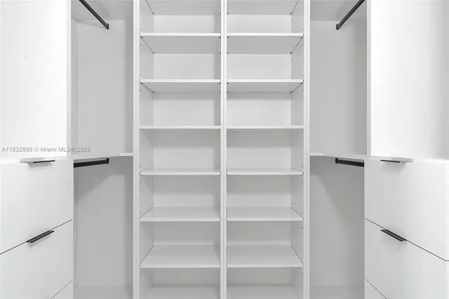 a view of walk in closet with empty racks