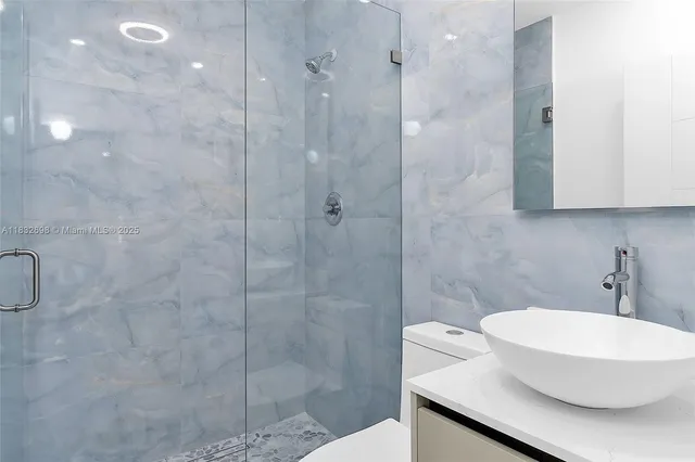 a bathroom with a toilet a sink a shower and a window