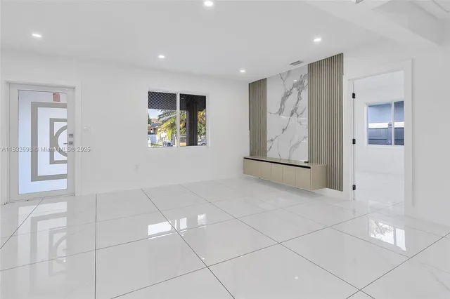 a view of an empty room with window and bathroom