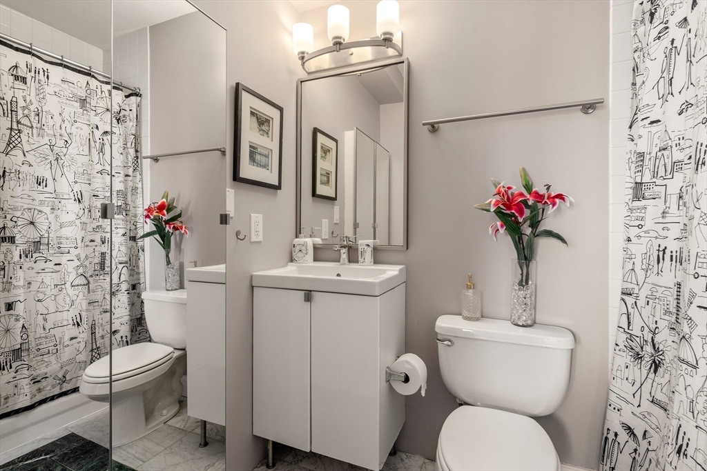 534 Beacon Street, Unit 707 Boston, MA 02215 - Photo 9 of 16 a bathroom with a toilet sink and mirror