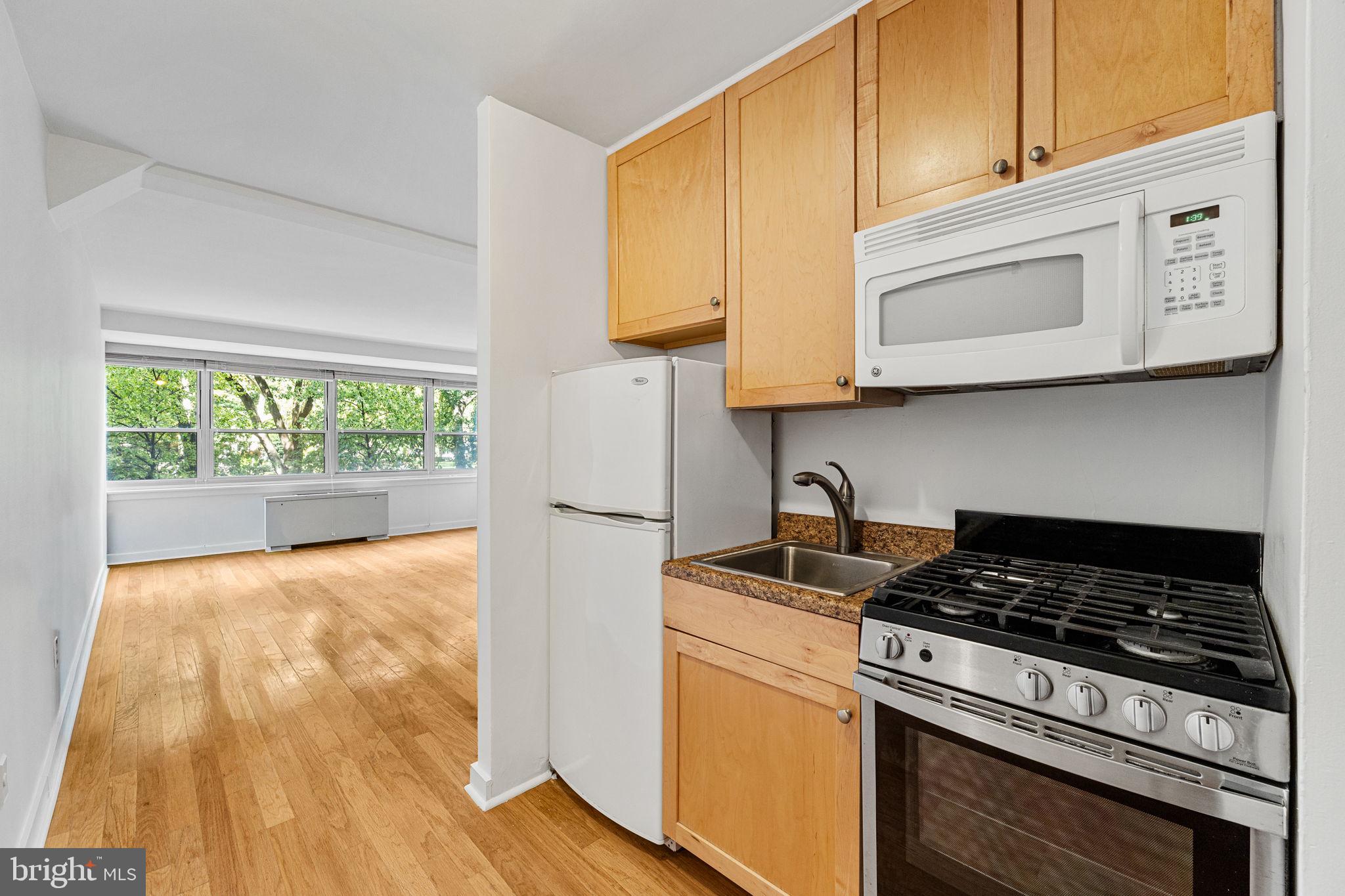 a kitchen with wooden floor and a stove top oven
