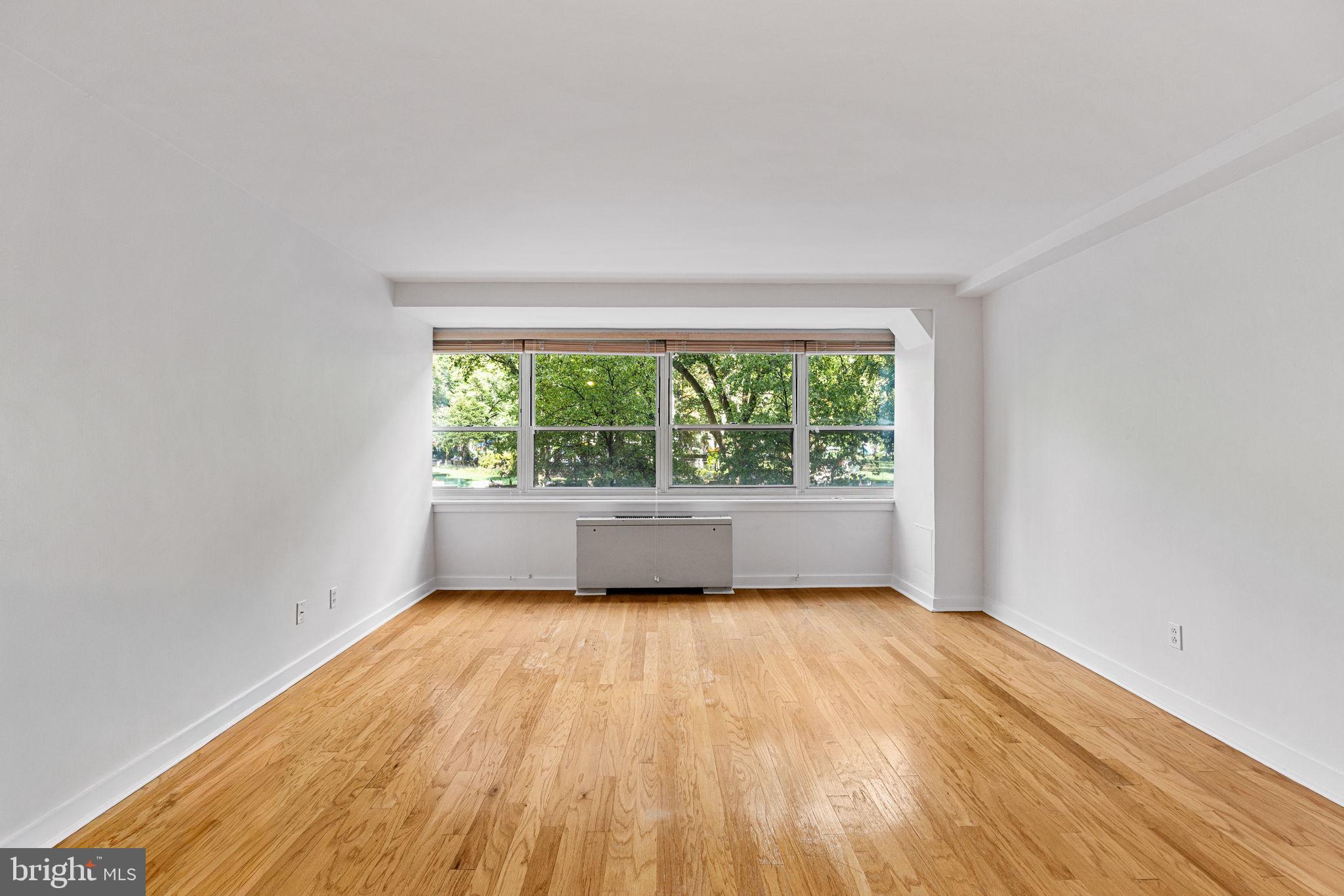 1810 Rittenhouse Square, Unit 203 Philadelphia, PA 19103 - Photo 7 of 15 an empty room with wooden floor and windows