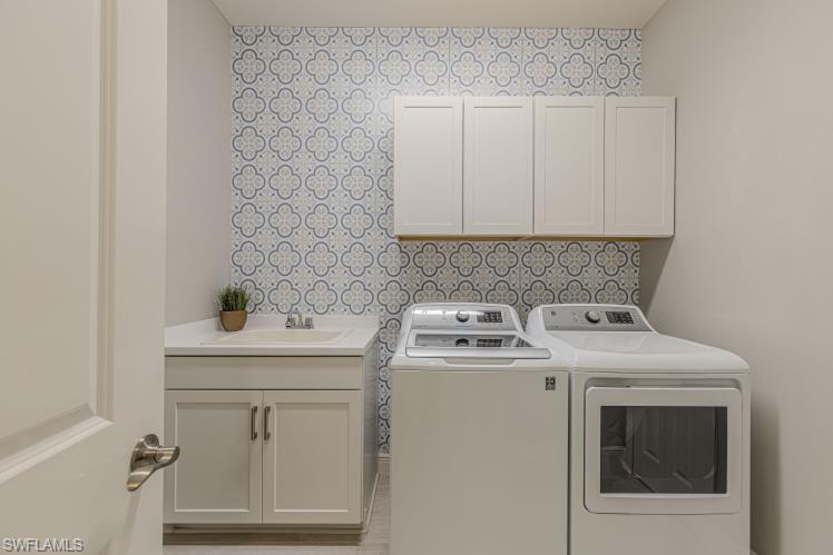 2199 Marquesa Circle Naples, FL 34112 - Photo 12 of 26 Laundry room with washer and dryer and cabinet space