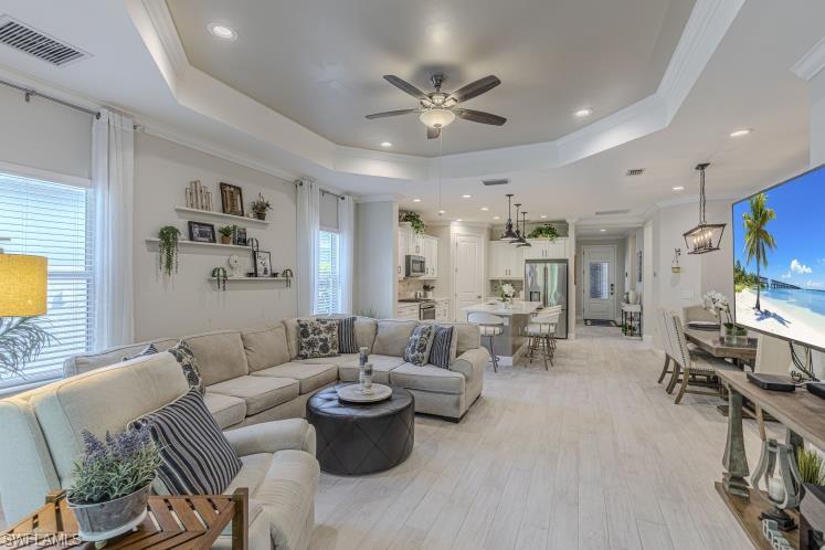2199 Marquesa Circle Naples, FL 34112 - Photo 2 of 26 Living room with ceiling fan, light wood-type flooring, crown molding, a tray ceiling, and recessed lighting