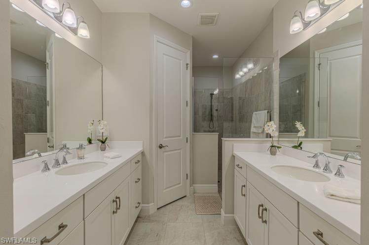 2199 Marquesa Circle Naples, FL 34112 - Photo 10 of 26 Full bathroom with two vanities and tiled shower