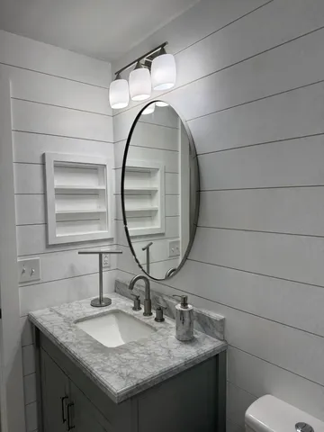 a bathroom with a granite countertop sink and a mirror