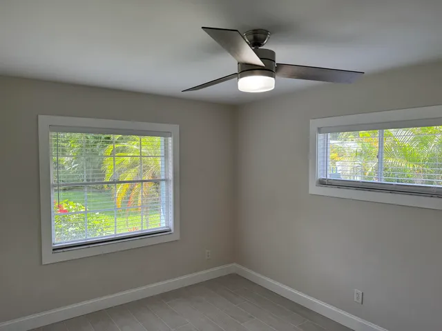 a room with ceiling fan and window
