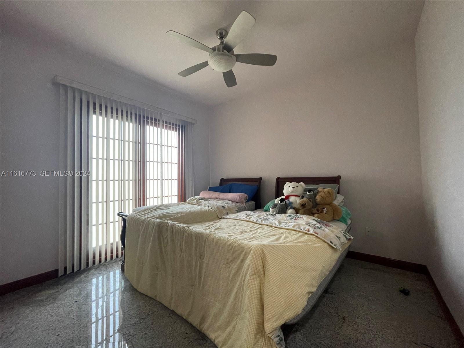 31002 Southwest 212th Avenue Homestead, FL 33030 - Photo 12 of 30 a bed sitting in a bedroom next to a window