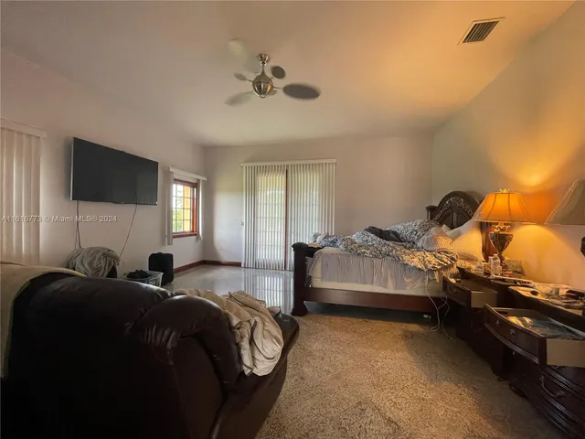 a bedroom with a bed and a flat tv screen on dresser
