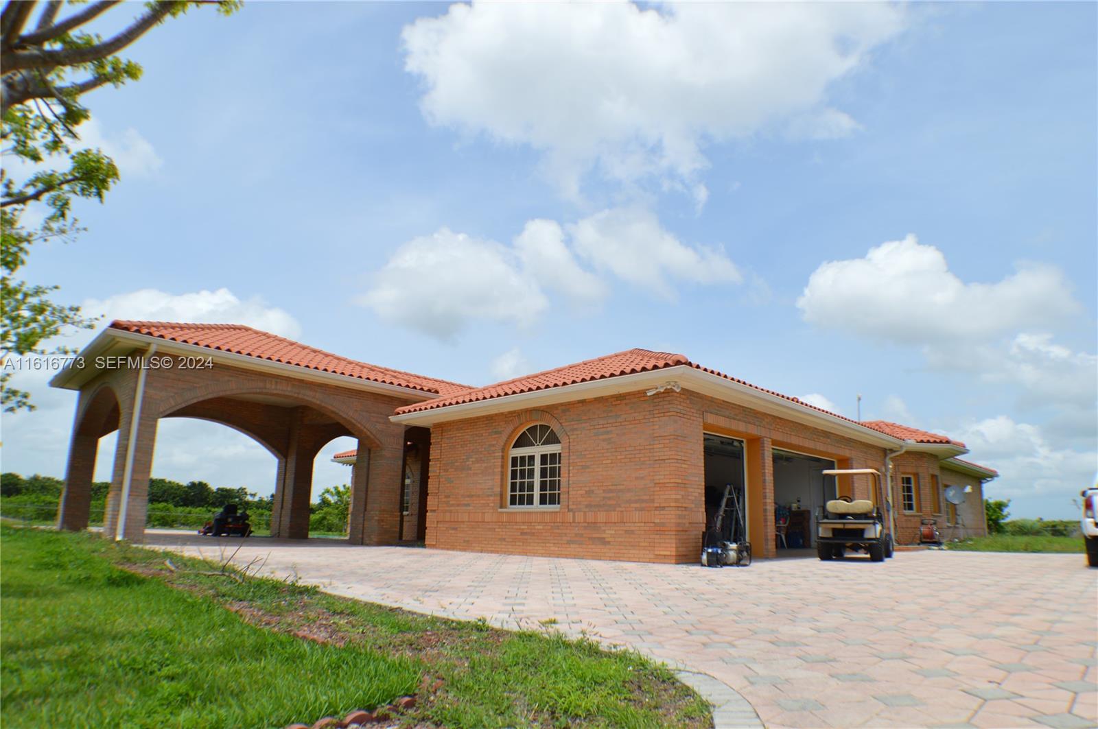 31002 Southwest 212th Avenue Homestead, FL 33030 - Photo 2 of 30 a front view of a house with yard and garage