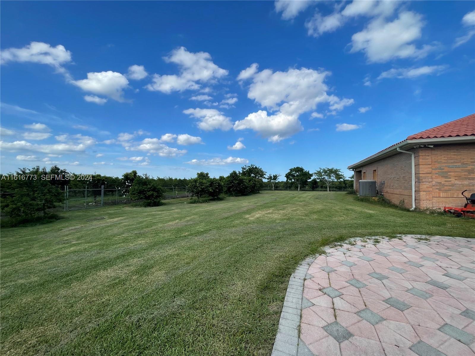 31002 Southwest 212th Avenue Homestead, FL 33030 - Photo 22 of 30 a view of a backyard with grass & a lake