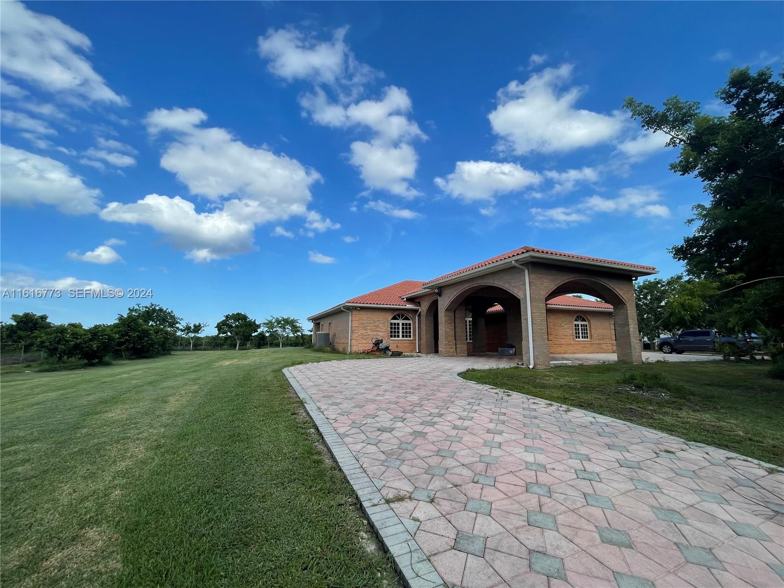 31002 Southwest 212th Avenue Homestead, FL 33030 - Photo 23 of 30 a front view of a house with a yard