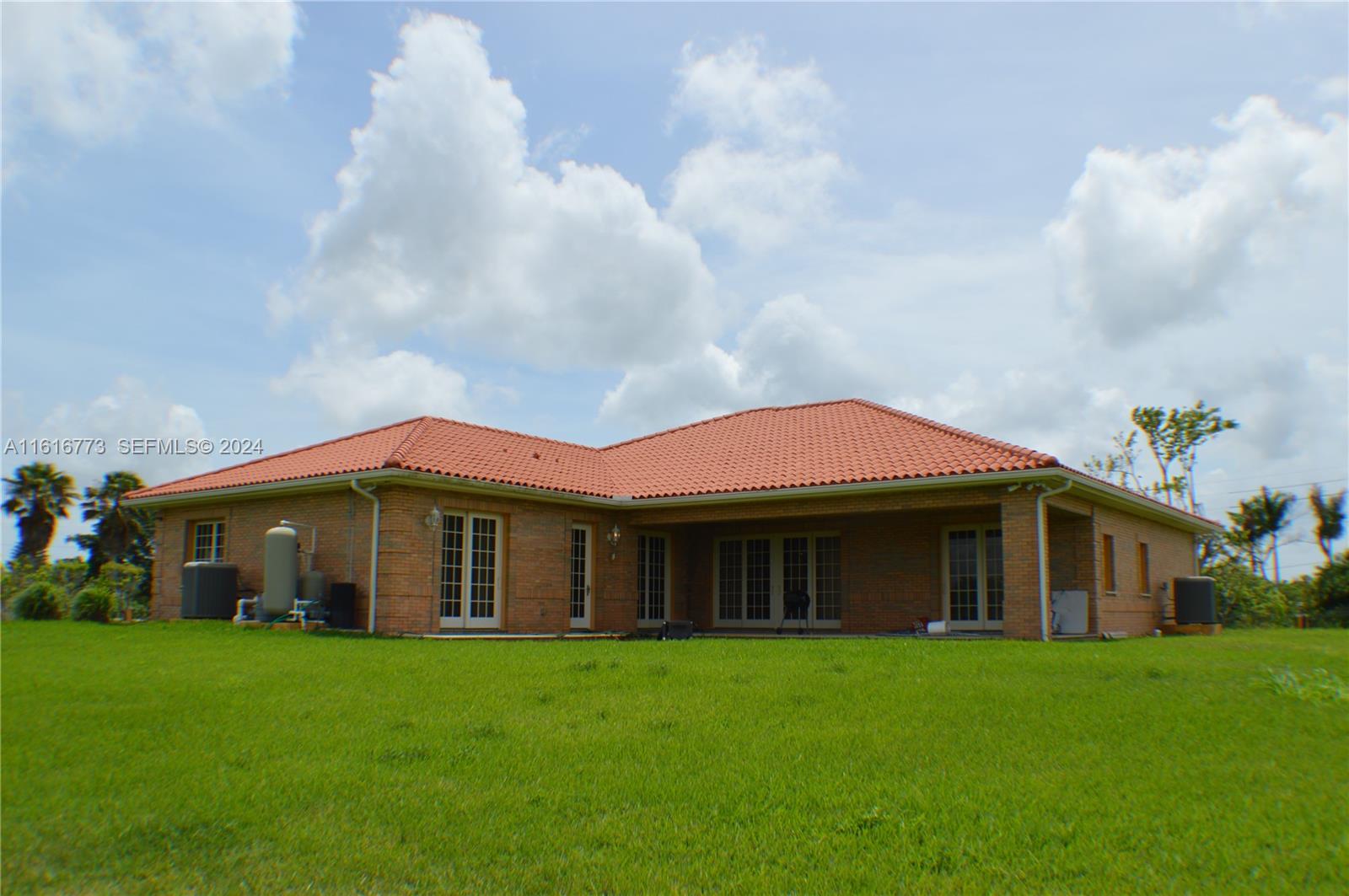 31002 Southwest 212th Avenue Homestead, FL 33030 - Photo 4 of 30 a front view of a house with a garden