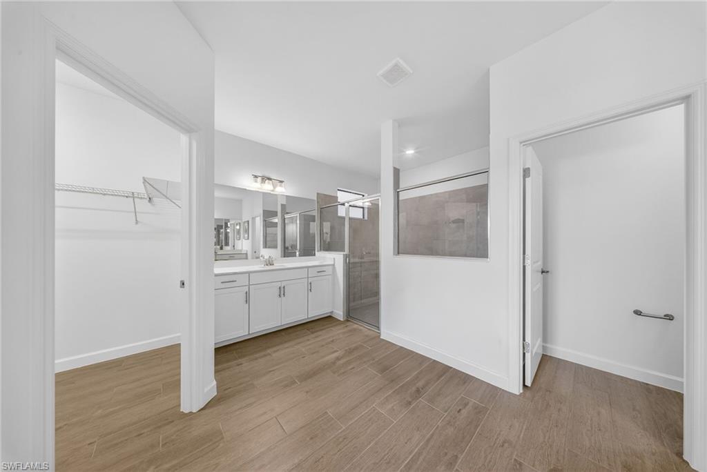 21082 Verawood Loop Estero, FL 33928 - Photo 22 of 50 a large white room with kitchen island wooden floor and white doors