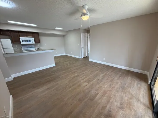 wooden floor in an empty room with a kitchen