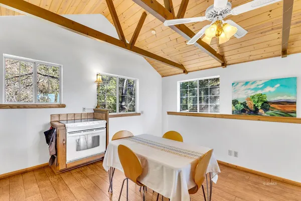 a view of a dining room with furniture a kitchen and wooden floor