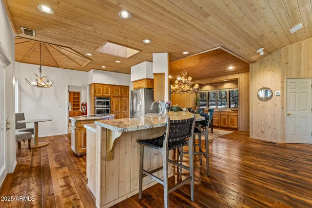 a living room with furniture a large window and wooden floor