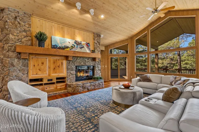 a living room with furniture a fireplace and a floor to ceiling window