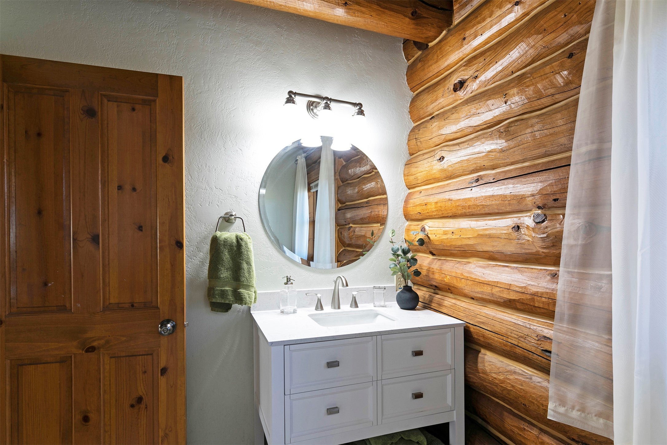 203 Hart Bench Road Darby, MT 59829 - Photo 17 of 56 The main floor bath artfully blends Montana log-inspired design with sleek, contemporary finishes, creating a space that is both warm and sophisticated.
