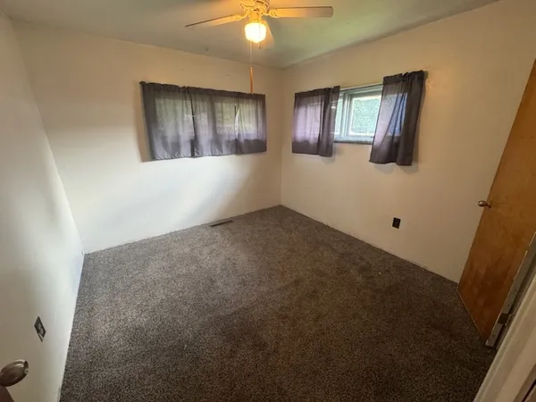 an empty room with windows and cabinet