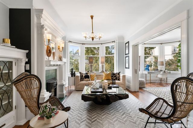 a living room with furniture a fireplace and large windows