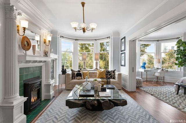 a living room with furniture large window and fireplace