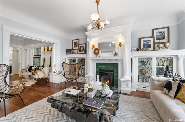 a living room with furniture a fireplace and a chandelier