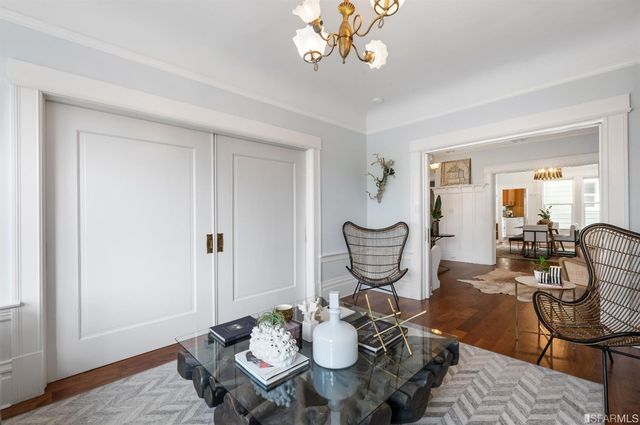 a view of a dining room with furniture a chandelier and wooden floor