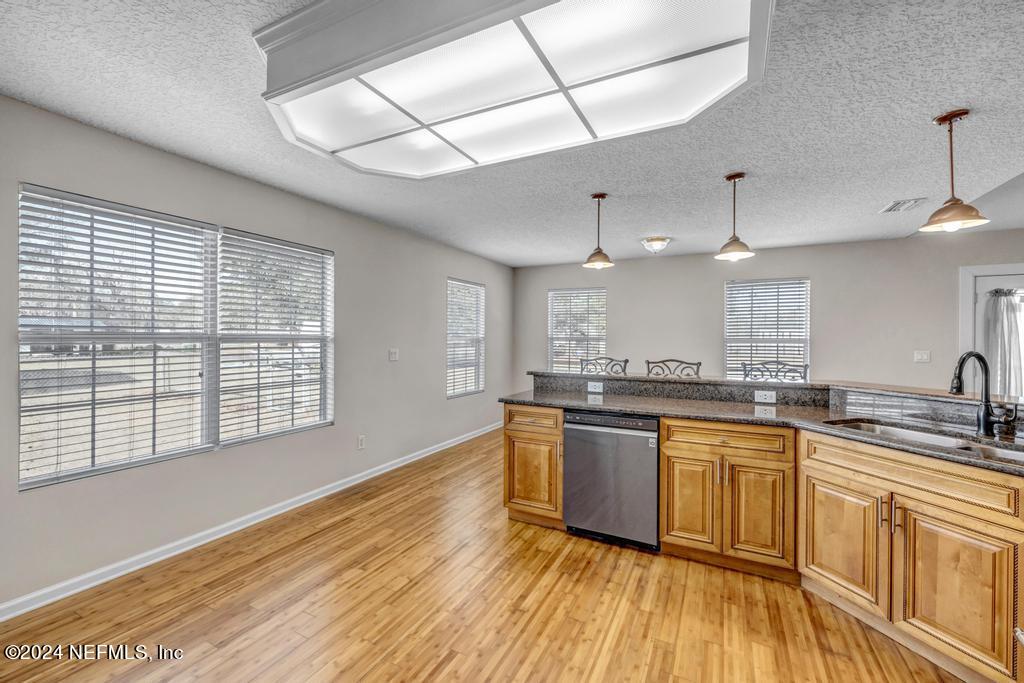 3308 Thunder Road Middleburg, FL 32068 - Photo 13 of 39 a large kitchen with stainless steel appliances granite countertop a sink and wooden floor