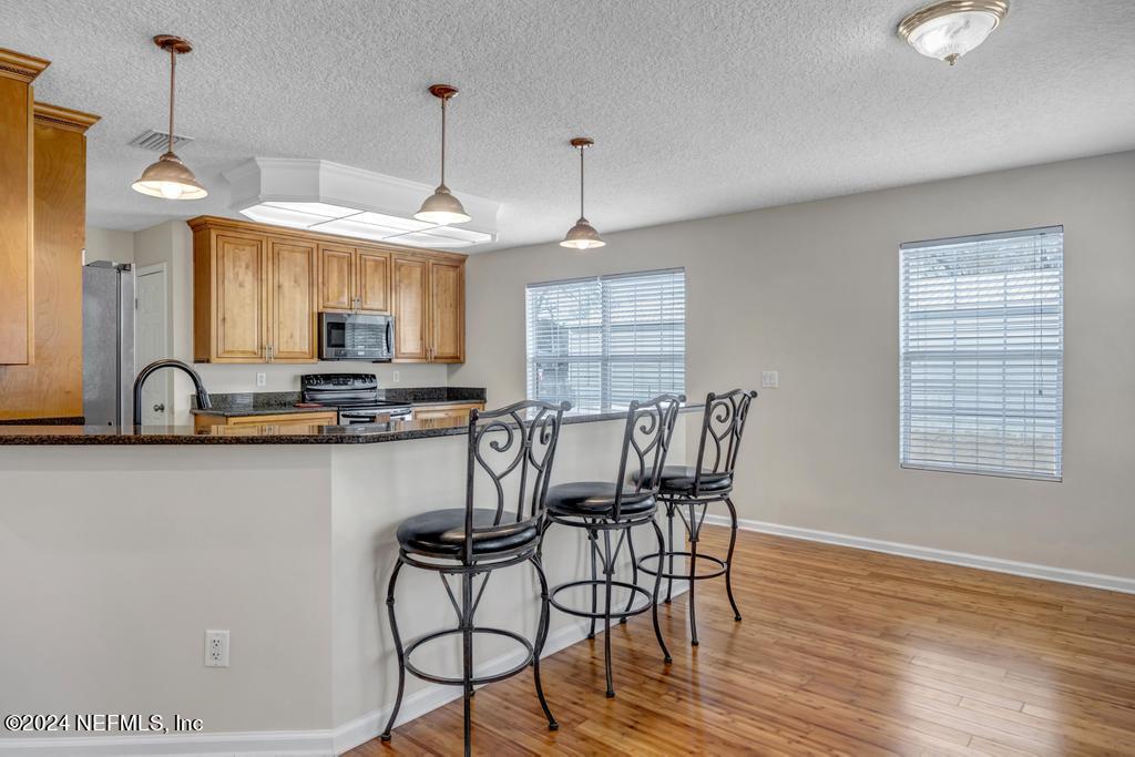 3308 Thunder Road Middleburg, FL 32068 - Photo 9 of 39 a kitchen with stainless steel appliances granite countertop a stove a sink and a wooden floors