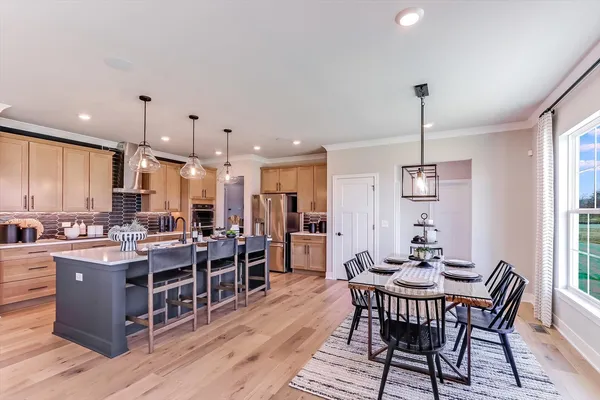 a living room with furniture kitchen view and a chandelier