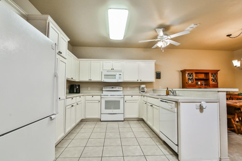 3118 113th Street Lubbock, TX 79423 - Photo 4 of 24 a kitchen with cabinets appliances a sink and a stove top oven