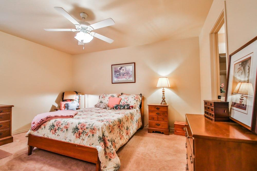 3118 113th Street Lubbock, TX 79423 - Photo 7 of 24 a bedroom with a bed and a chandelier