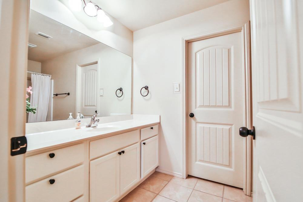 3118 113th Street Lubbock, TX 79423 - Photo 9 of 24 a spacious bathroom with a double vanity sink a mirror and a