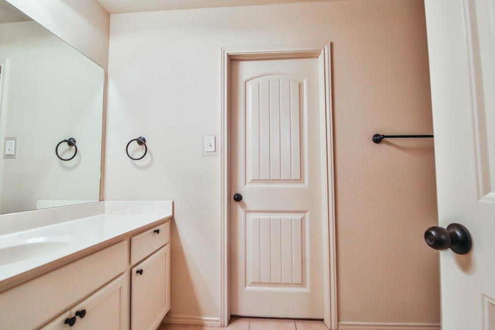 3118 113th Street Lubbock, TX 79423 - Photo 10 of 24 a bathroom with a sink and a mirror