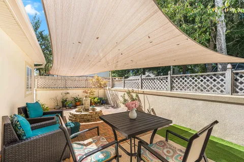 a backyard of a house with table and chairs