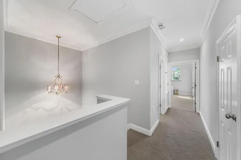 a spacious bedroom with a bed and a flat tv screen on the dresser