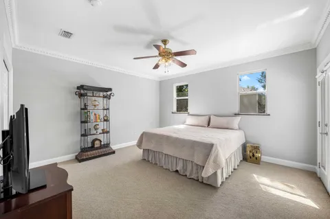 a bedroom with a large bed a flat tv screen and dresser