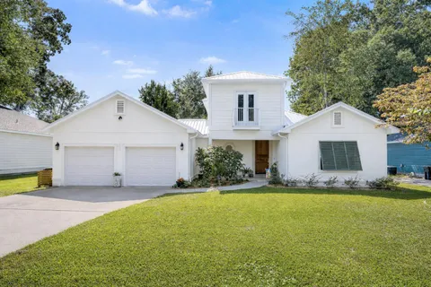 a front view of house with yard and trees in the background