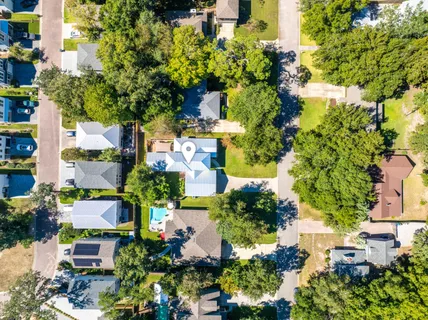 an aerial view of ocean and residential houses with outdoor space
