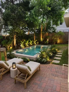 a view of a patio with table and chairs potted plants and large tree