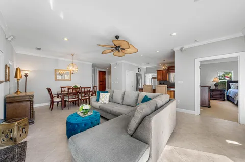a living room with furniture kitchen view and a chandelier