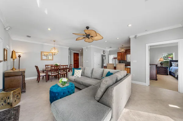 a living room with furniture kitchen view and a chandelier