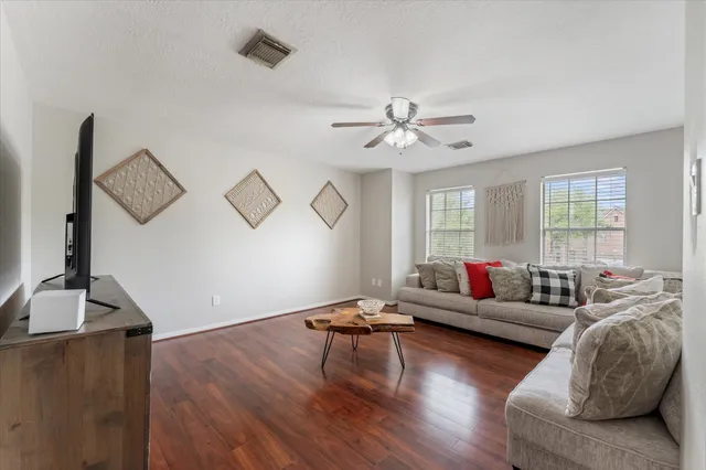 a living room with furniture and wooden floor